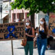 Zwei Frauen mit medizinischen Masken und Transparenten auf einer Demo für bessere Forschung und Versorgung von ME/CFS Patient:innen